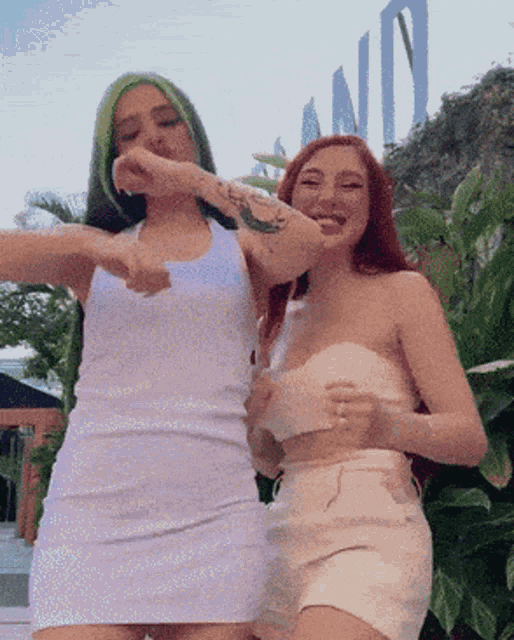 two women are standing next to each other in front of a sign that says nd