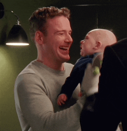 a man is holding a baby in his arms and laughing