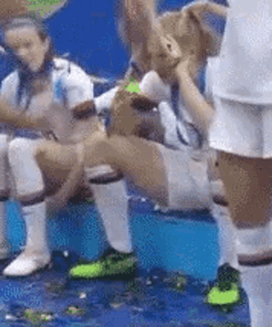 a group of soccer players are sitting on a bench with their legs crossed .