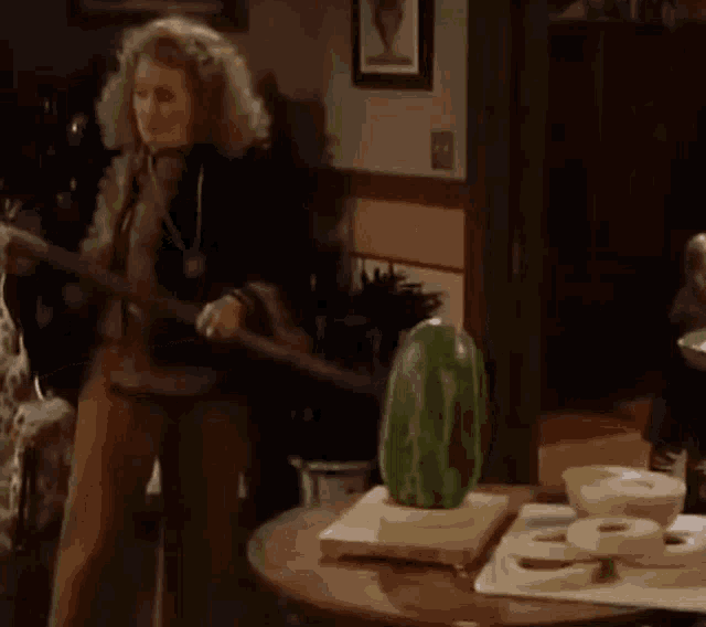 a woman is sitting in a chair next to a table with a cactus on it