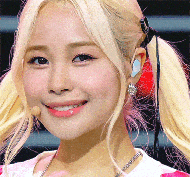 a close up of a woman 's face with blonde hair and a microphone