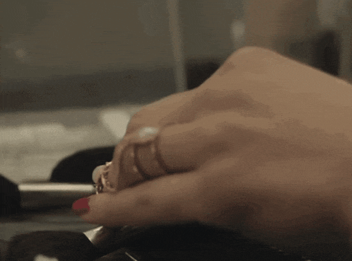 a close up of a woman 's hand with multiple rings on it