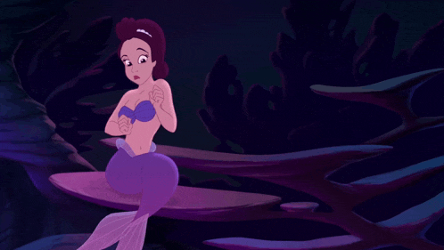 a purple mermaid is sitting on a rock in a dark cave