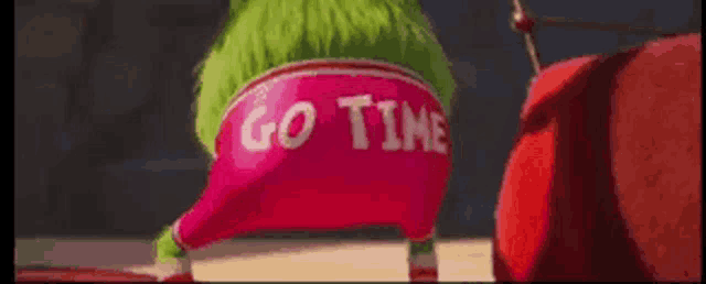 a cartoon character is wearing a pink hat with the words go tim written on it .