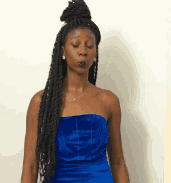 a woman wearing a blue strapless dress is making a face