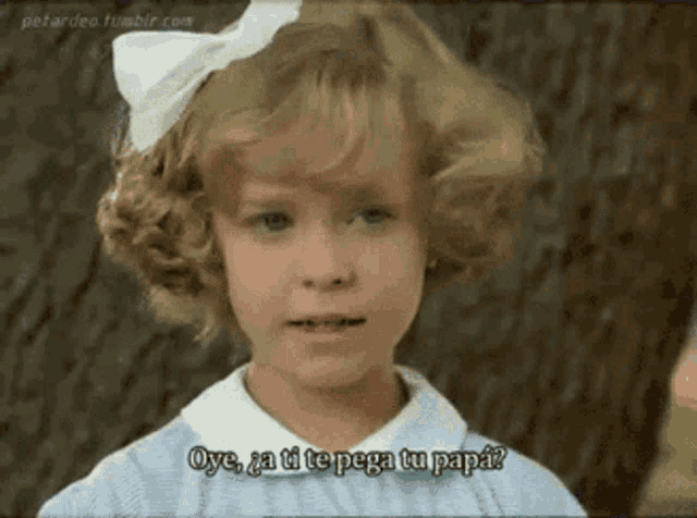 a little girl with a white bow in her hair says oye