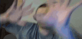 a blurry picture of a person 's face with their hands outstretched .