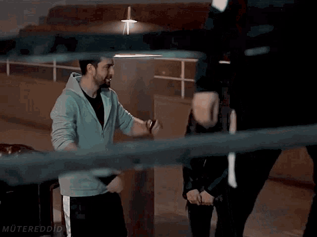 a man is kissing a woman on the forehead in a boxing ring