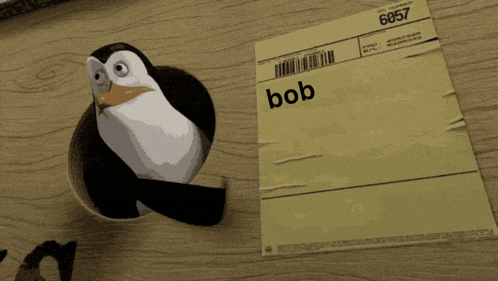 a penguin is sticking its head out of a hole next to a piece of paper with bob written on it