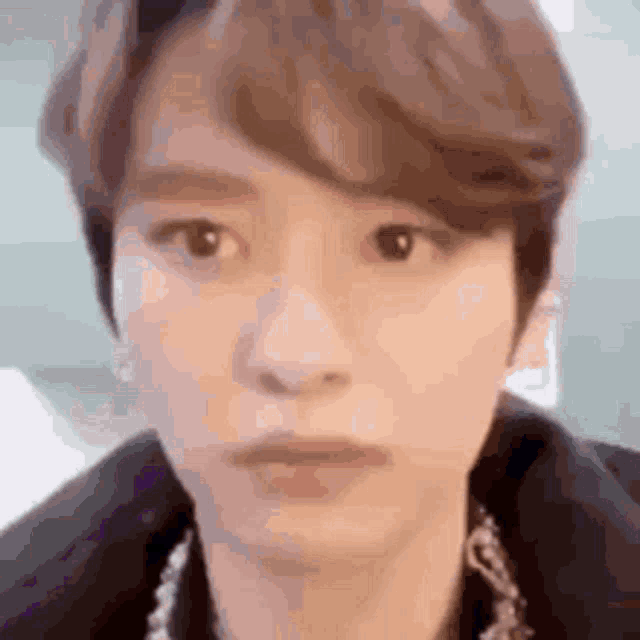 a close up of a young man 's face with a serious look on his face .