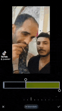 a man is smoking a cigarette while another man looks at him .