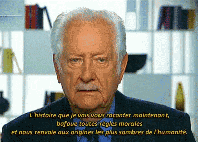a man in a suit and tie is speaking in a foreign language