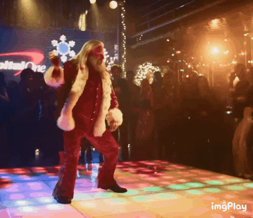 a man in a santa costume is dancing on a dance floor