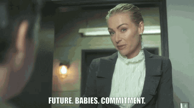 a woman in a suit talks to a man in a doorway and says future babies commitment