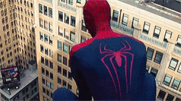 a man in a spiderman suit is sitting on a building