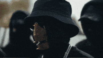 a man wearing a bucket hat and a mask with spikes on it