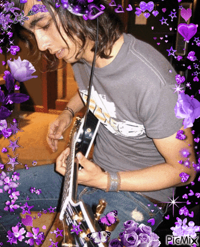 a picture of a man playing a guitar is surrounded by purple flowers