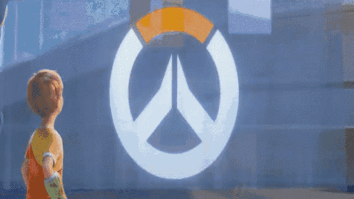 a little boy stands in front of a overwatch logo