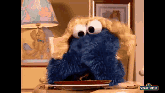 cookie monster from sesame street is eating a cookie on a plate