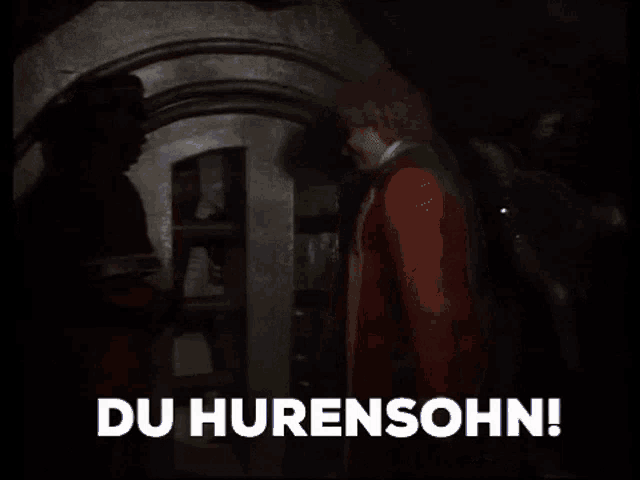 a man standing in a dark room with the words du hurensohn written on the bottom