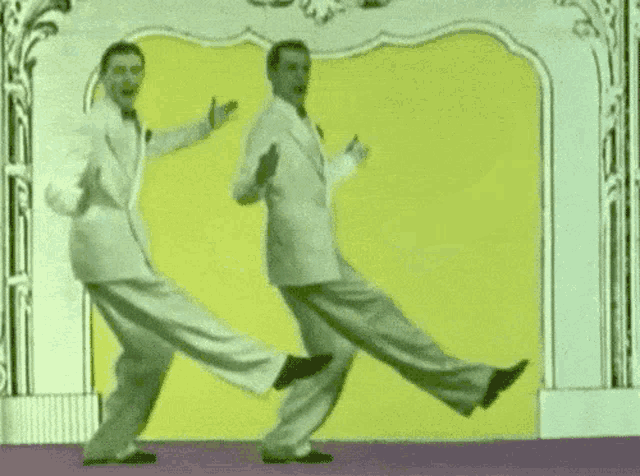 two men in suits and ties are dancing together