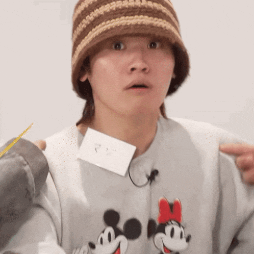 a person wearing a hat and a sweater with mickey mouse and minnie mouse on it