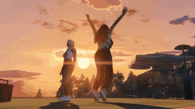two women are jumping in the air at sunset with their arms in the air