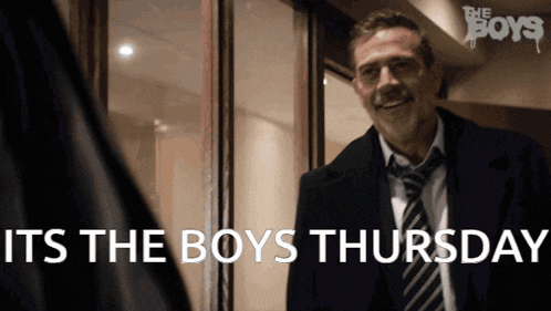 a man in a suit and tie says " it 's the boys thursday " in front of a door