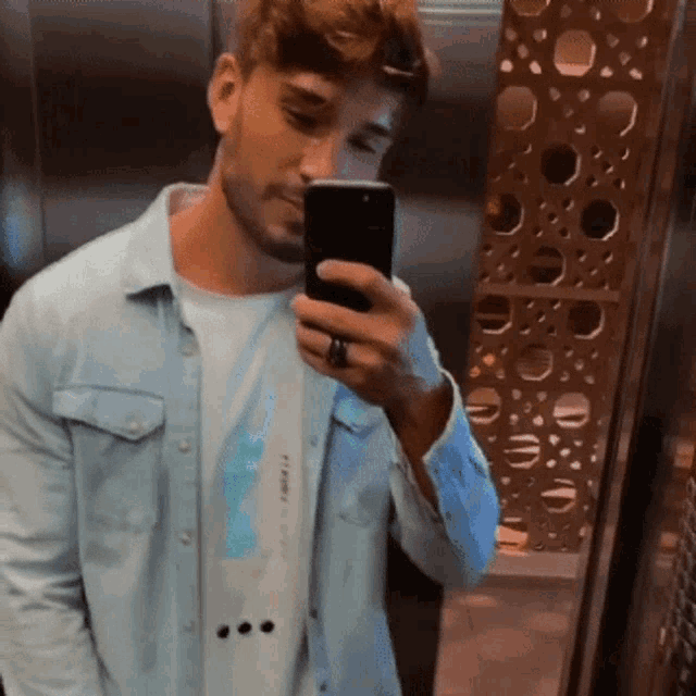 a man is taking a picture of himself in an elevator with his phone