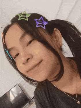 a girl with a ponytail and hair clips with stars on it