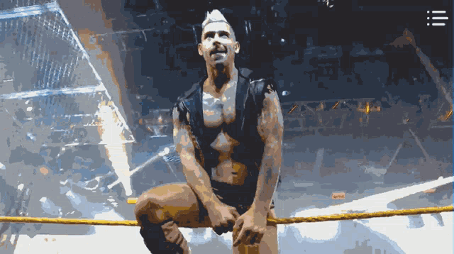 a man is sitting in a wrestling ring with a rope around his waist