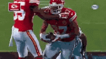 a group of football players are playing a game of football on a field .
