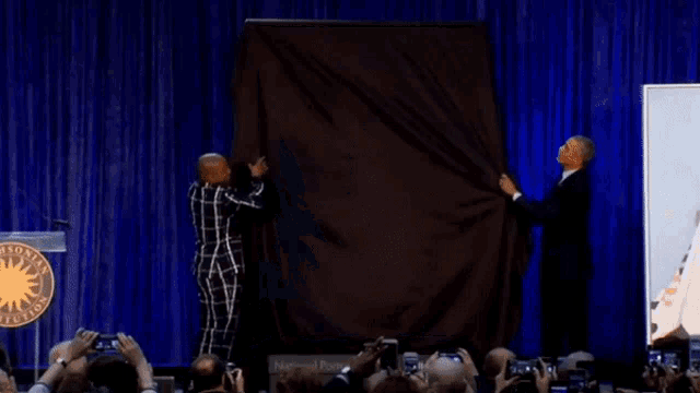 a group of people are taking pictures of a picture of a woman on a stage