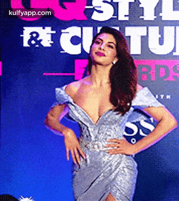 a woman in a very plunging dress is standing in front of a sign that says style & culture awards