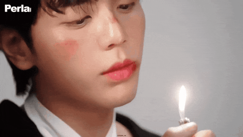 a close up of a person holding a lighter with the word perla in the corner