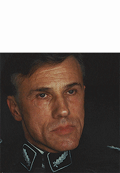 a close up of a man 's face with a collar that has a leaf on it