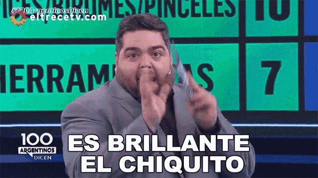 a man in a suit says " es brillante el chiquito " in spanish