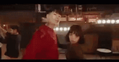 a group of people are dancing on a dance floor in a room .