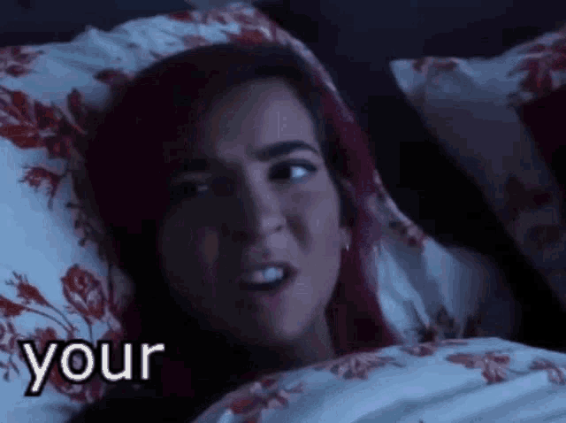 a woman with purple hair is laying in bed with the word your written on the bottom