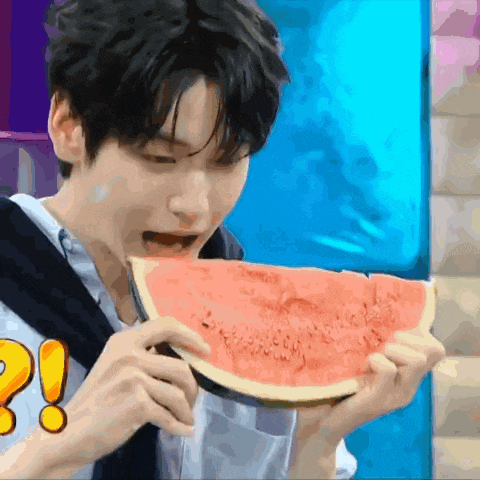 a young man is eating a slice of watermelon with an exclamation point on it