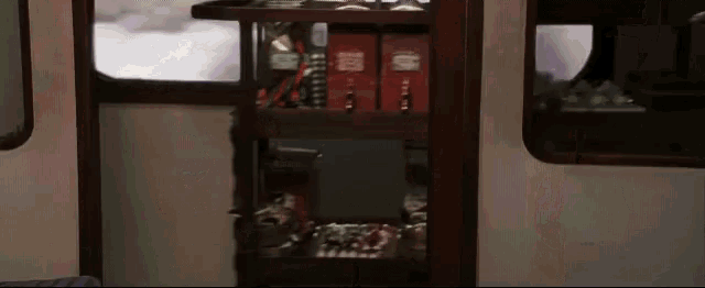a shelf in a train car has a few books on it including one that says ' harry potter ' on it