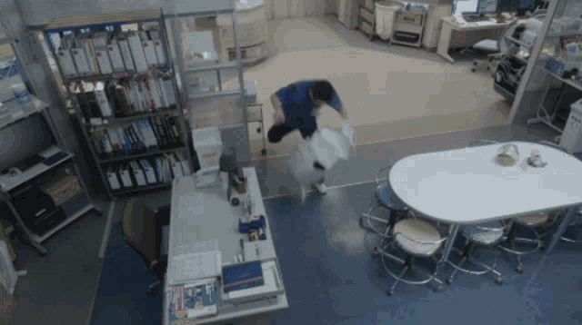 a man is standing in a room with a table and chairs