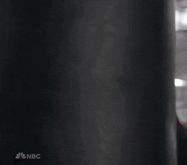 a woman wearing boxing gloves is running in front of a punching bag .