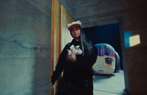 a woman wearing a cat hat holds a stuffed animal in front of a statue of a girl