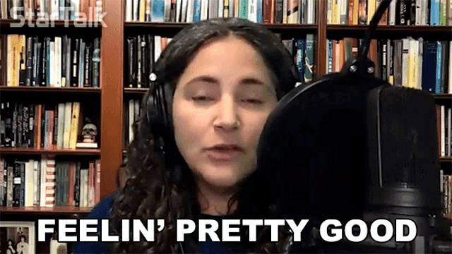 a woman wearing headphones is singing into a microphone and the words feelin ' pretty good are next to her