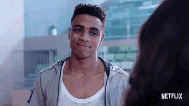 a man is smiling in front of a sign that says netflix on it