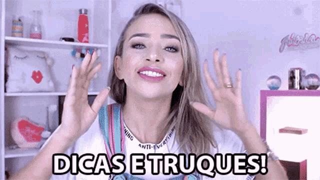 a woman says dicas e truques in front of a pink shelf
