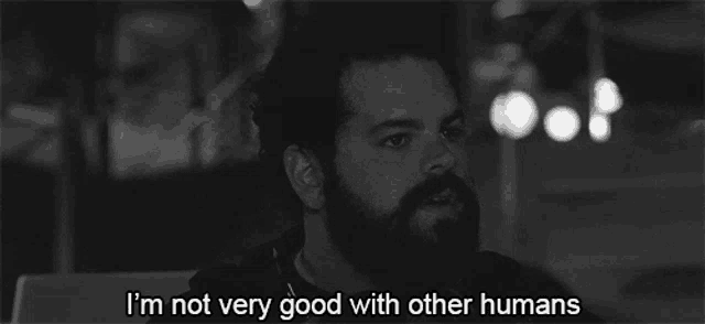 a man with a beard says " i 'm not very good with other humans " in a black and white photo