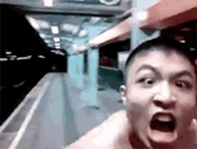 a man without a shirt is making a funny face while standing on a platform .
