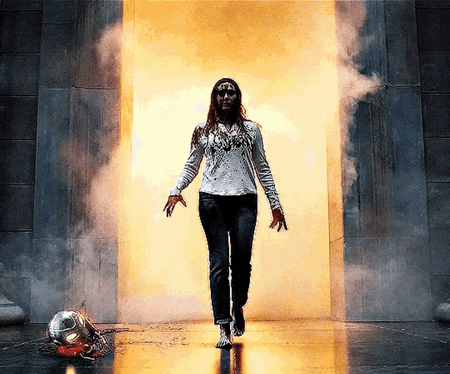 a woman in a white shirt and jeans is walking through a doorway